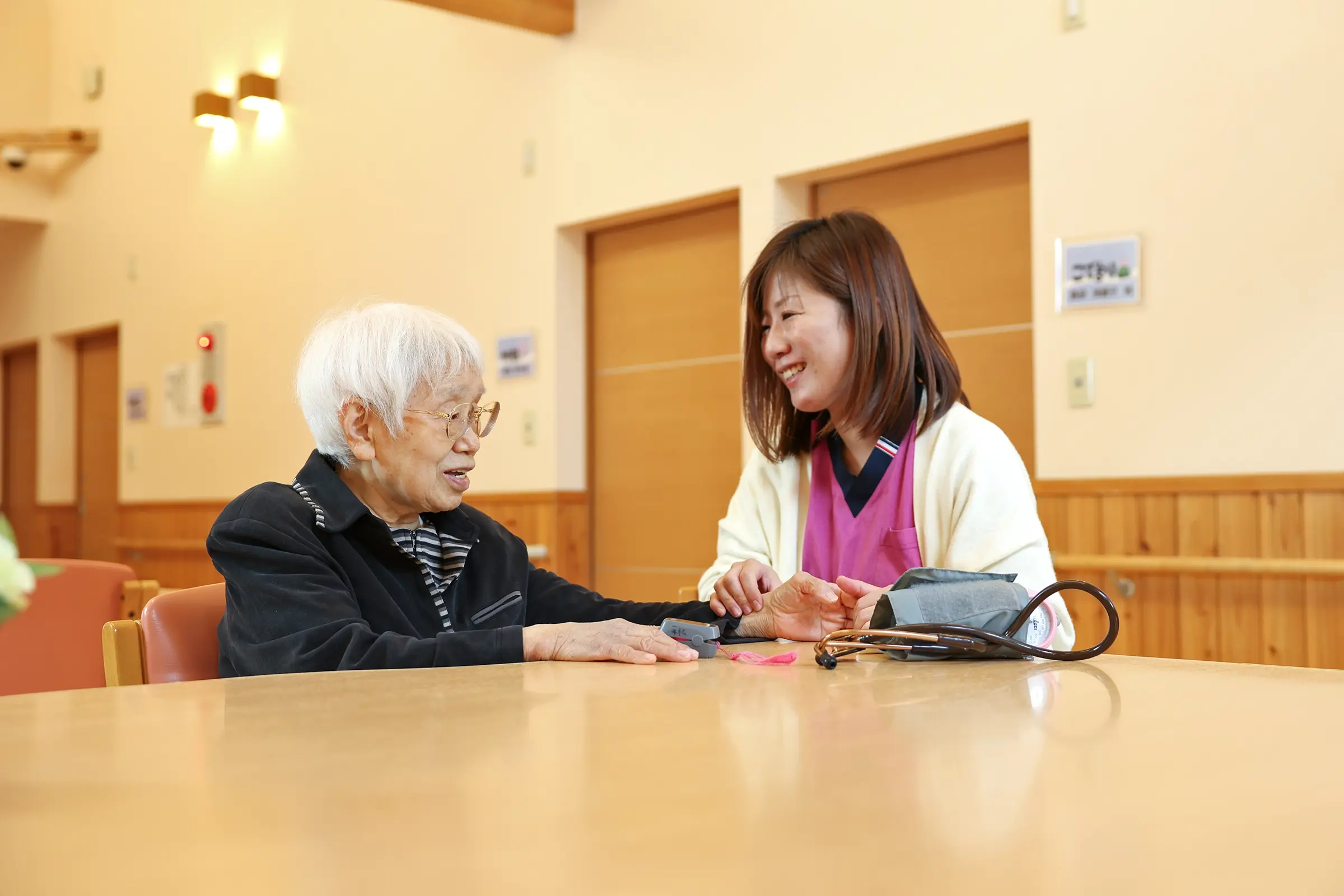 訪問看護で血圧測定を受ける高齢女性